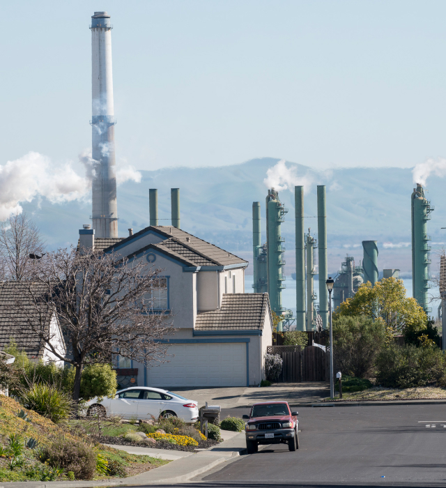 Residential street with fog from power plant chimneys in the background